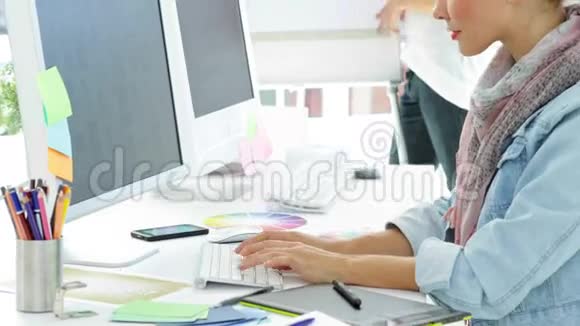 集中的创意经理在她的办公桌上工作视频的预览图