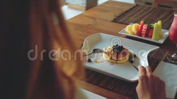 木桌上有蓝莓薄煎饼水果果汁和咖啡视频的预览图