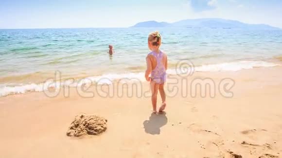 小女孩在浅青色的海水中向母亲奔跑视频的预览图