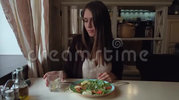 坐在城市咖啡馆里吃沙拉的女性视频的预览图