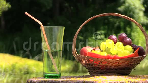 石桌上的玻璃水水果女孩享受温暖的天气视频的预览图