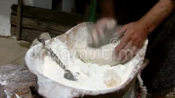 老妇人在木碗里揉面团视频的预览图