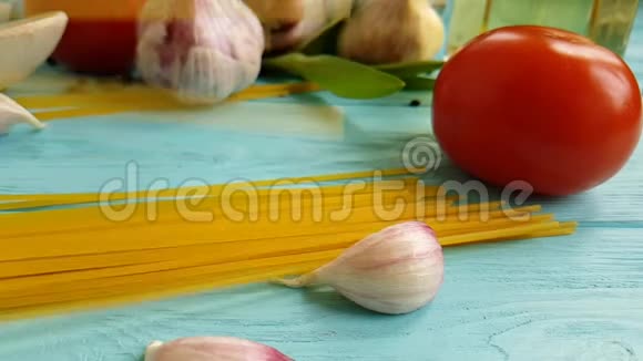 意大利面油菜单营养意大利面一瓶素食慢动作大蒜番茄黑胡椒粉蓝色木制背景视频的预览图