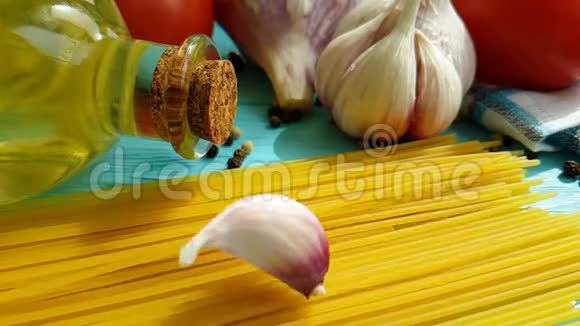 意大利面条油菜意大利面一瓶素食慢动作大蒜番茄黑胡椒在蓝色木制背景上视频的预览图