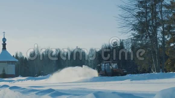 拖拉机向后行驶并从冬季道路上清除积雪视频的预览图