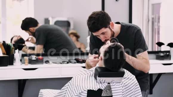 一位职业商人被理发师修剪胡子视频的预览图