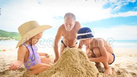小女孩爷爷蹲在沙滩上冲浪视频的预览图