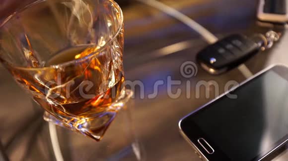 一杯酒精饮料和汽车钥匙放在桌子上背景轻视频的预览图