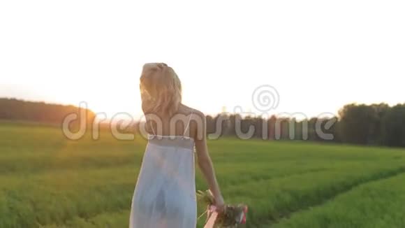 美丽的女人带着一束鲜花走在田野里视频的预览图