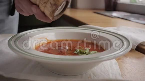 一盘番茄汤配上奶酪和手中的烤面包倒入现代咖啡馆视频的预览图