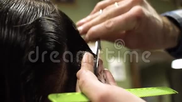口渴的过程理发师给一个留胡子的年轻人剪头发的特写视频的预览图