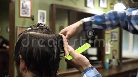 口渴的过程理发师给一个留胡子的年轻人剪头发的特写视频的预览图
