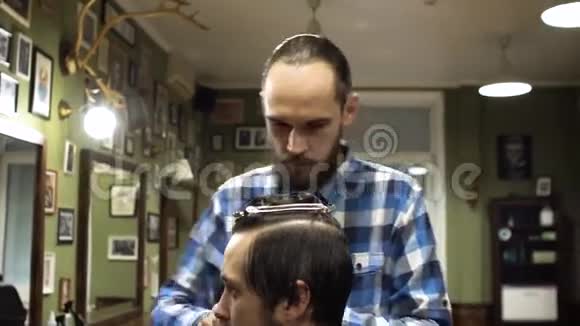 理发师在理发店用剪刀和梳子剪客户的头发视频的预览图
