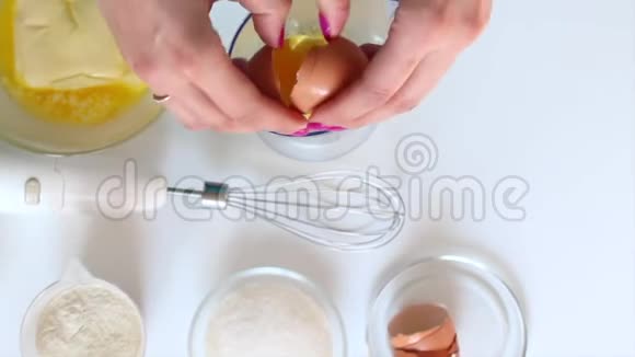 一个女人正在准备面团用搅拌机混合鸡蛋和糖视频的预览图