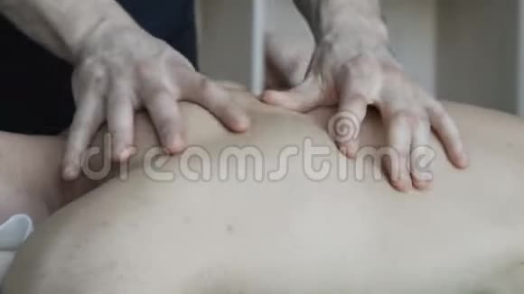 按摩治疗师给男性按摩背部4K视频的预览图