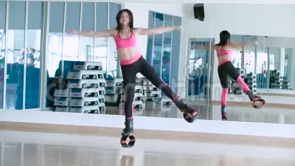 微笑的女人在舞蹈室里和kangoo鞋跳舞视频的预览图