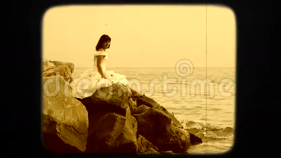 穿着白衣坐在海上的年轻女子视频的预览图