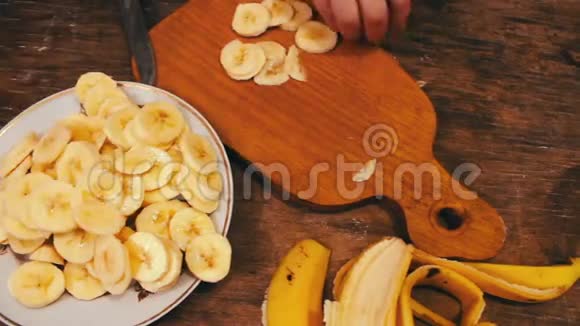用刀在木板上切香蕉的特写视频的预览图