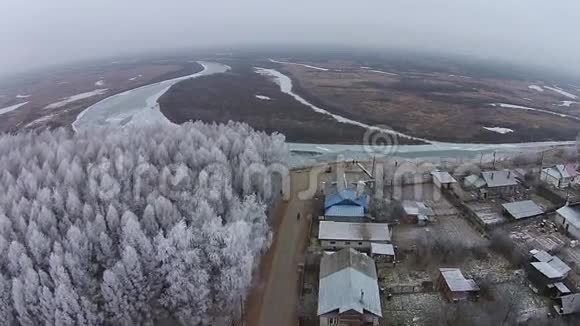 在村里飞越冬季河流视频的预览图