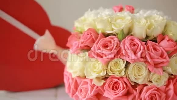 精致的粉色和白色玫瑰花束有礼物的盒子以心脏的形式视频的预览图