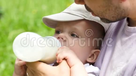爸爸在户外用奶瓶喂宝宝视频的预览图