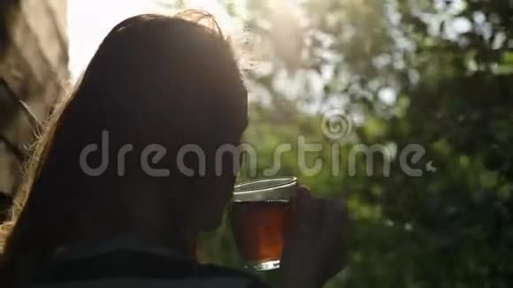 日落时在户外喝茶的女人视频的预览图