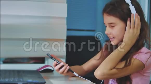 小女孩听音乐耳机智能手机生活方式十几岁的女孩在播放列表音乐视频的预览图
