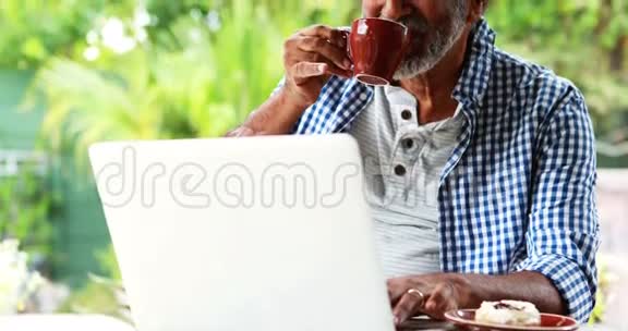 喝咖啡时使用手提电脑的老人视频的预览图