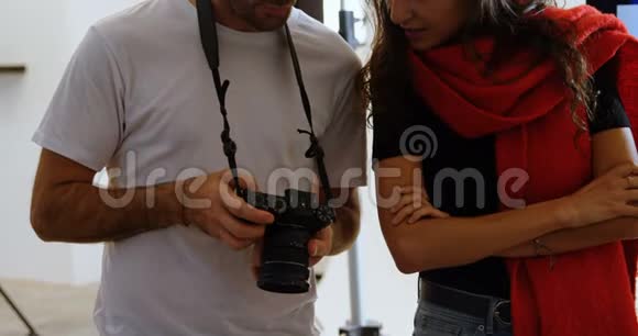 男性摄影师和模特在照片4k上讨论视频的预览图