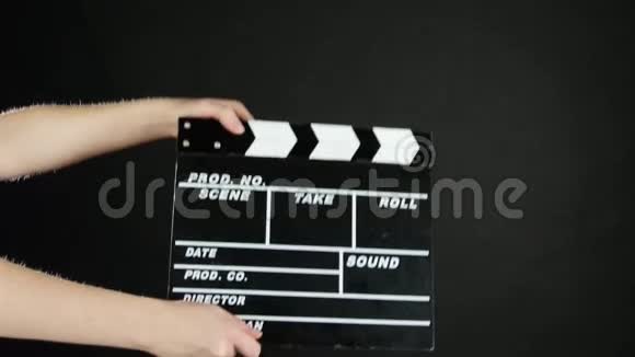 双手使用黑色电影制作板视频的预览图