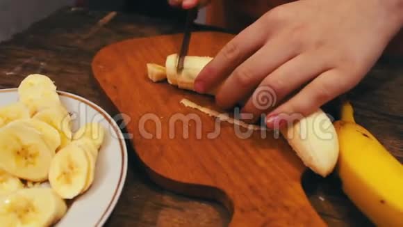 用刀在木板上切香蕉的特写视频的预览图
