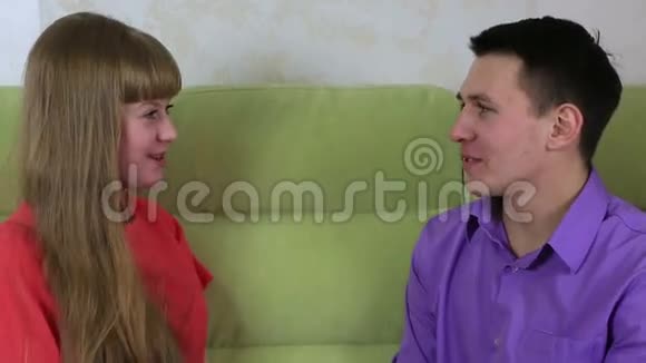漂亮的年轻人和女人坐在沙发上他送女孩礼物视频的预览图