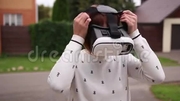 年轻的红头发妇女使用VR头盔智能手机增强现实视频的预览图