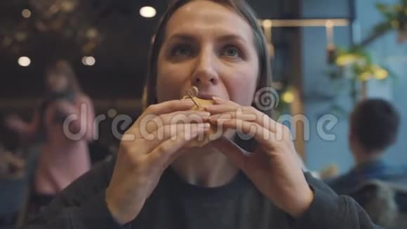 女人在咖啡馆里吃汉堡视频的预览图