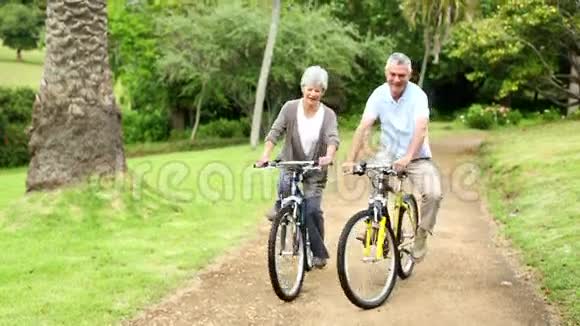 在公园里骑自行车的退休夫妇视频的预览图