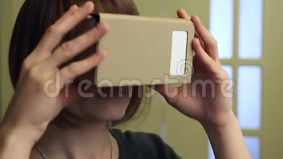 虚拟现实眼镜中的年轻女性纸板VR360视频的预览图