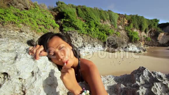 诱人的淘气女孩舔海滩上的棒棒糖视频的预览图