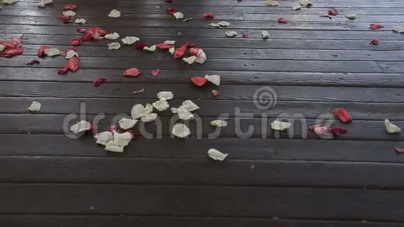 木地板上的玫瑰花瓣带滑块的高清镜头视频的预览图