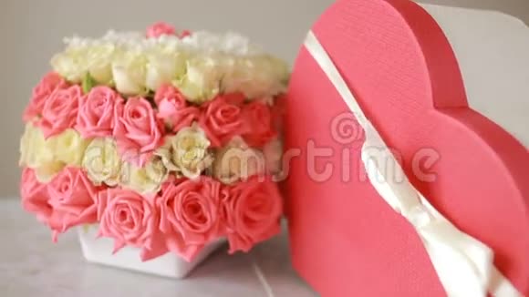 精致的粉色和白色玫瑰花束有礼物的盒子以心脏的形式视频的预览图