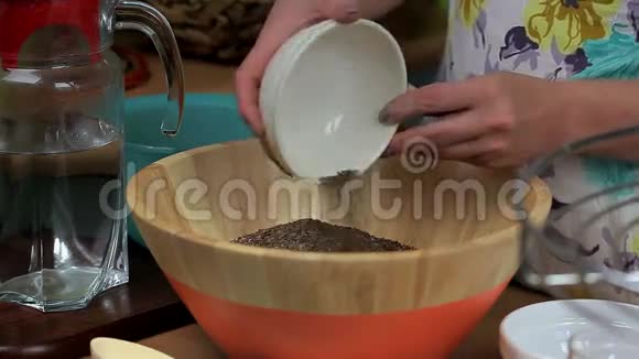 女人在碗里加入孜然水和面包面团视频的预览图