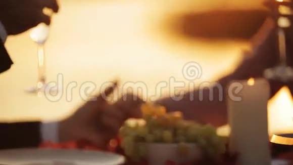 日落时分在海滩餐厅浪漫约会的情侣视频的预览图