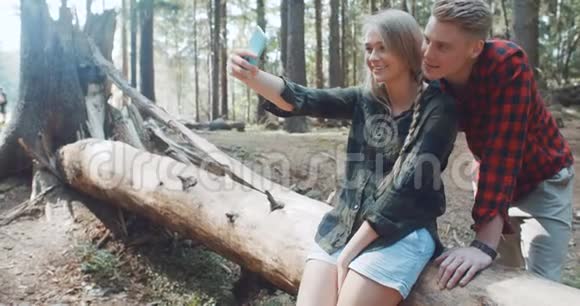 可爱的年轻白种人夫妇在森林里拍摄自我肖像视频的预览图