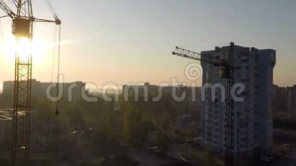 日出时工业建筑起重机和建筑轮廓视频的预览图