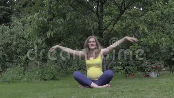 健康的孕妇在户外做瑜伽放松视频的预览图