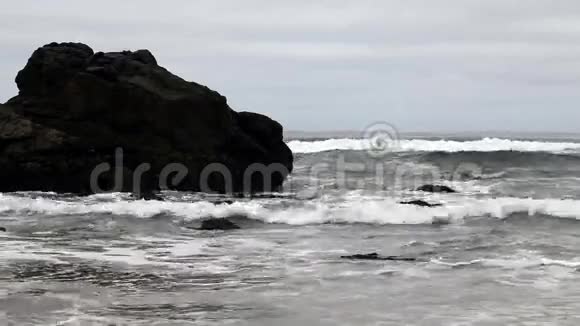 温和的海浪冲击岩石日视频的预览图