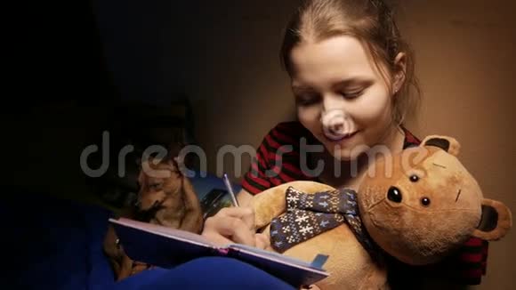 十几岁的孩子在家里写日记她带着一只玩具熊和一只小狗4UHDK视频的预览图