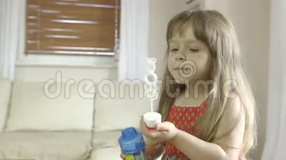可爱的小白种人女孩在家里玩和做肥皂泡视频的预览图