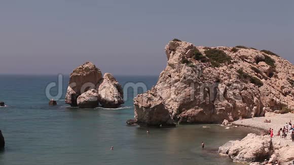 人们在塞浦路斯岛上的阿芙罗狄蒂的出生地一个小沙滩上洗澡和日光浴岩石就会伸出手来视频的预览图