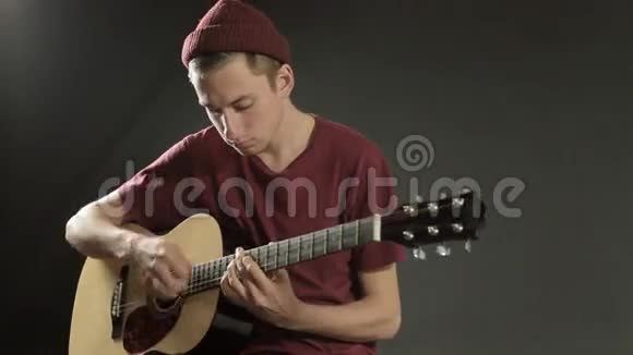 在黑暗工作室弹吉他的年轻音乐家视频的预览图