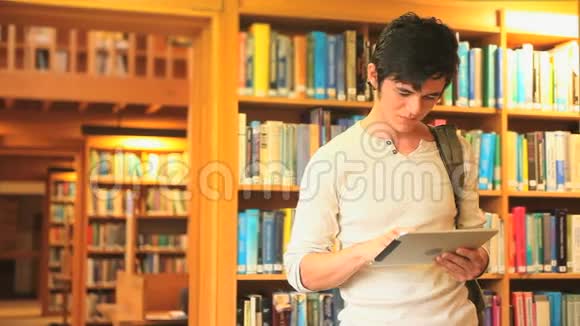 英俊的年轻人在他的平板电脑上看书视频的预览图
